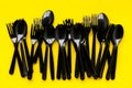 Plastic spoons and forks utilization and the Earth protection concept with flatware on yellow background top view Royalty Free Stock Photo