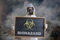 Ecology and pollution concept. Man in coveralls is warning against biohazard waste