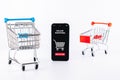 Ecommerce application. Digital smartphone with online shop app, shopping trolley on white background. Website retail