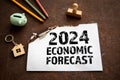 2024 Economic Forecast Concept. Sheet of paper with text on a rusty metal background