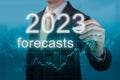 Economic forecasts for 2023. businessman writes forecasts for 2023 on virtual screen. Post covid-19 economic recovery. Businessman