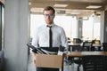 Economist leaving office. Handsome economist leaving the office taking his box with different things