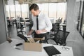 Economist leaving office. Handsome economist leaving the office taking his box with different things Royalty Free Stock Photo