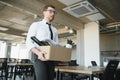 Economist leaving office. Handsome economist leaving the office taking his box with different things Royalty Free Stock Photo
