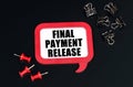 On a black surface, office supplies and a red plaque with the inscription - Final payment Release