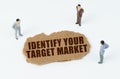 On a white background, figures of businessmen and torn cardboard with the inscription - IDENTIFY YOUR TARGET MARKET Royalty Free Stock Photo