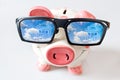 Economy and finance - piggy bank with glasses and dreamed house