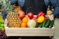 Ecoproduct. A set of fresh vegetables and fruits in a box, which the man holds in his hands. The man in the apron Royalty Free Stock Photo