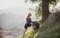 Ecotourism concept. Woman hiker hiking with backpack at hills. Tourist girl climb climbing in mountains with backpacking