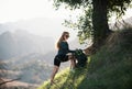 Ecotourism concept. Woman hiker hiking with backpack at hills. Tourist girl climb climbing in mountains with backpacking