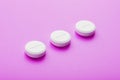 Ecstasy pills in a row on a pink background, isolate