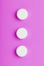 Ecstasy pills in a row on a pink background, isolate.