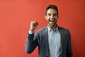 Ecstatic businessman cheering in front of a red background