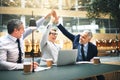 Ecstatic businesspeople high fiving each other in an office Royalty Free Stock Photo