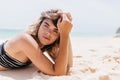 Ecstatic european woman chilling at beach in sunny day. Debonair girl in striped bikini resting at resort..