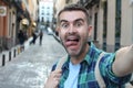 Ecstatic man taking a selfie outdoors