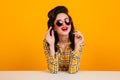 Ecstatic pinup girl posing in heart shaped glasses. Studio shot of dreamy elegant woman in checkered shirt Royalty Free Stock Photo