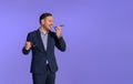 Ecstatic young businessman holding eyeglasses and communicating over smart phone. Male manager in elegant suit laughing and Royalty Free Stock Photo