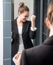 Ecstatic young smart woman saying yes with joyful arms raised