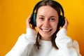 Ecstatic young woman wearing headphones enjoys good music and has fun.