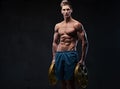 Ectomorph shirtless athletic male holds barbell weight.