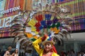 Ecuadorian folklore dancer is posing with a big decorative wheel feather ornamental hat on her head in a sunny summer day.