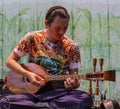 ED-Bankgok, Thailand - 2019-30-13 - Man Plays Mandolin While Sitting on Tapestry