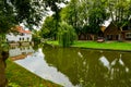 Edam, Netherlands, August 2019. One of the pretty canals of this city: the foliage of the trees is reflected on the water along Royalty Free Stock Photo