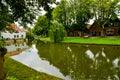 Edam, Netherlands, August 2019. One of the pretty canals of this city: the foliage of the trees is reflected on the water along Royalty Free Stock Photo