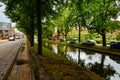 Edam, the Netherlands, August 2019. One of the pretty canals of this town: the foliage of the trees is reflected on the water Royalty Free Stock Photo