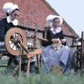 Craftswomen using an old spinning wheel to turn wool into yarn