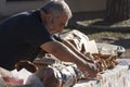 Ederly man preparing pizza with mortadella