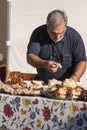 Ederly man preparing pizza with mortadella and porchetta sandwich