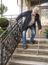 Ederly man in protective mask with a cane descends down the stairs Royalty Free Stock Photo