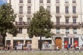 Edestrians walking on rue de la Republique Street in Lyon, France, facing a Haussmann style building and some commercial shops