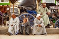 Edfu, Egypt - Jan 2019: People of Egypt, Egyptians in traditional clothing waiting around Edfu Temple. Carriages that they use to
