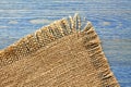 Edge of burlap cloth on a blue table Royalty Free Stock Photo