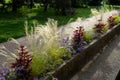 On the edge of the elevated terrace overlooking the park is a concrete long flowerpot with a concrete bench. is part of the city c