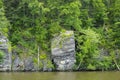 Rock Face of Gneiss on Edge of Green Forestalong Riverbank