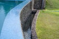 The edge of an infinity pool, draining over a ledge. Resort swimming pool Royalty Free Stock Photo