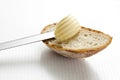 Edge of white bread with curl of butter, close up.