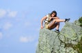 On edge of world. Woman sit on edge of cliff in high mountains blue sky background. Hiking peaceful moment. Enjoy the Royalty Free Stock Photo