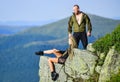 On edge of world. Woman sit edge of cliff high mountains landscape background. Couple hikers enjoy view. Hiking peaceful