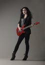 Edgy rocker woman playing red guitar Royalty Free Stock Photo