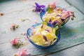 Edible flowers salad in a plate on blue wooden table with fork Royalty Free Stock Photo