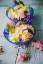 Edible flowers salad in a plate on blue wooden table with fork Royalty Free Stock Photo