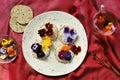 Edible flowers snacks with flower tea as a healthy and happy breakfast on a red background