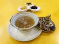 Edible maroon Bird`s nest soup in benjarong bowl served with sweetened side dish in Royalty Free Stock Photo