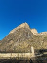 Edinburgh castle on rocky hill seen from below with bright blue sky behind Royalty Free Stock Photo