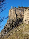 Edinburgh castle on rocky hill seen from below with bright blue sky behind Royalty Free Stock Photo